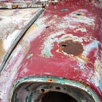 A close-up of a rusted hole in a car body panel