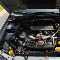 A car engine bay showing coolant and other fluid reservoirs