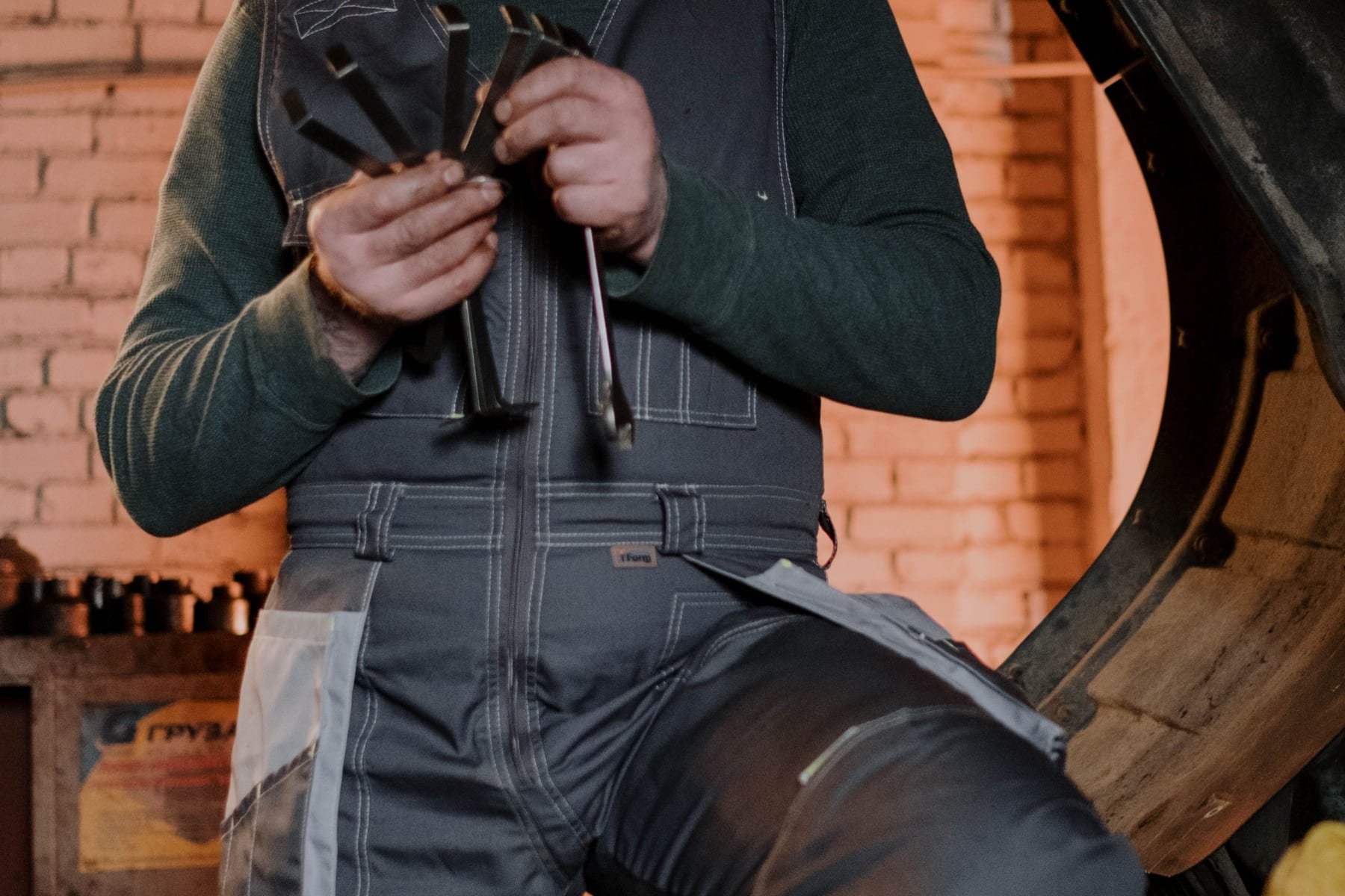 Hands inspecting ignition coils beside an open vehicle hood