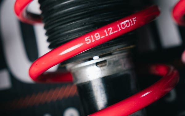 Close-up of a red performance coilover suspension spring