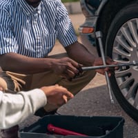 A wrench being used to tighten a wheel's lug nuts